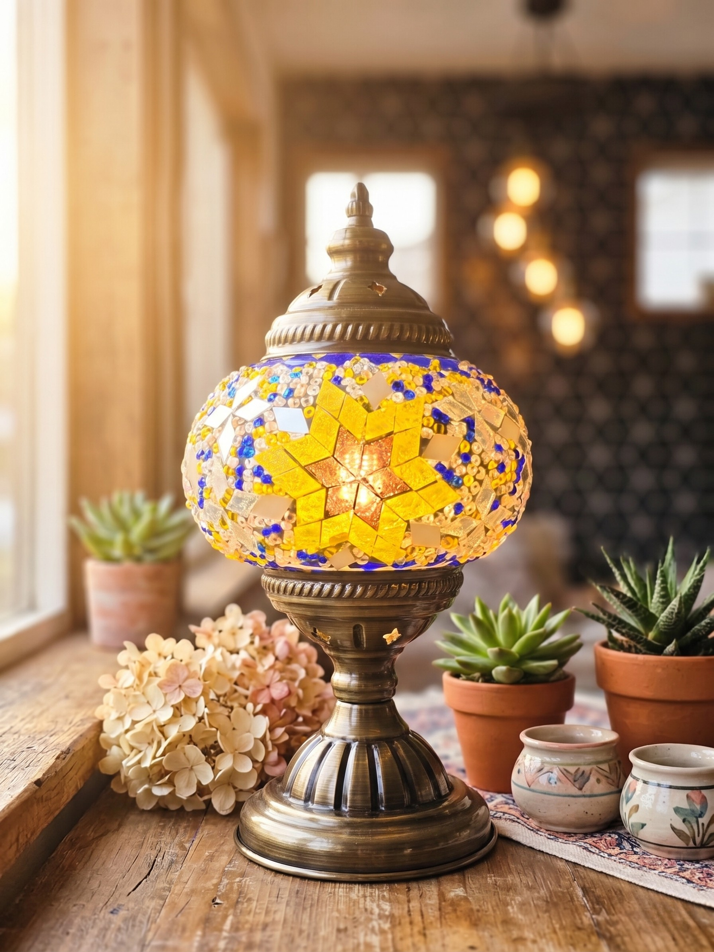 Decorative lamp with star design on a wooden table with plants and flowers.